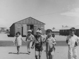 Pre-school children on the way to their barrack homes from morning class at this War Relocation Authority center for evacuees of Japanese ancestry