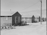 30 June1942. Manzanar Relocation Center, Manzanar, California. Barrack homes at this War Relocaton Authority center. The family in the foreground have commenced a flower garden to make their surroundings more home-like. National Archives, 538159.