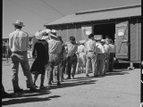 1 July 1942. Manzanar Relocation Center, Manzanar, California. Evacuees of Japanese ancestry at this War Relocation Authority center line up at warehouse Number 26 for their allotment of soap. Four bars of soap are distributed to each apartment on designated days. One representative of each apartment room must appear presenting his identification tag. National Archives, 537970.